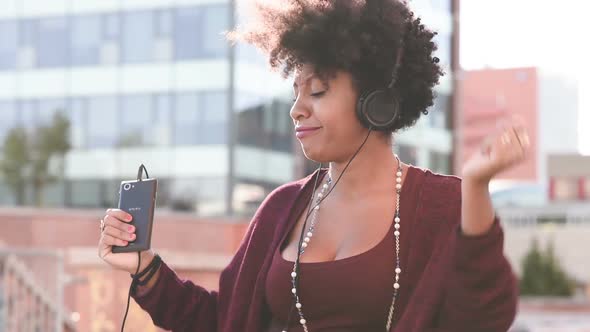 Young black woman dancing singing listening music