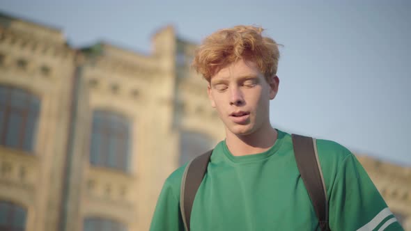 Portrait of Confident Intelligent Redhead Student at Sunset Outdoors. Young Caucasian Handsome Man