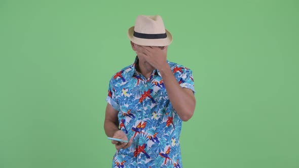 Stressed Multi Ethnic Tourist Man Using Phone and Getting Bad News