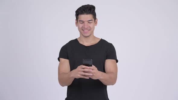 Happy Young Handsome Multi-ethnic Man Using Phone
