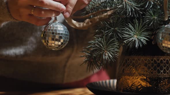 Girl Hangs a Christmas Decoration on the Christmas Tree