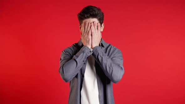 Young Guy Covers His Face with Hands From Fatal Disappointment, Failure. 