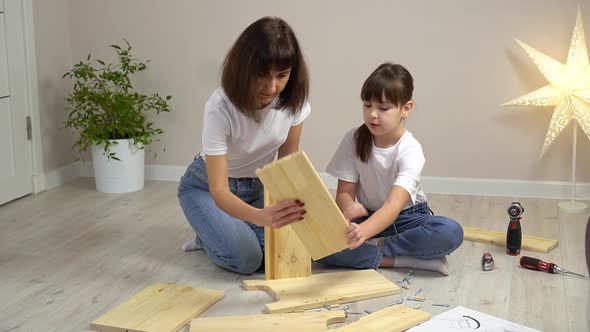 Happy Family Mother and Daughter Assembling Wooden Furniture Together