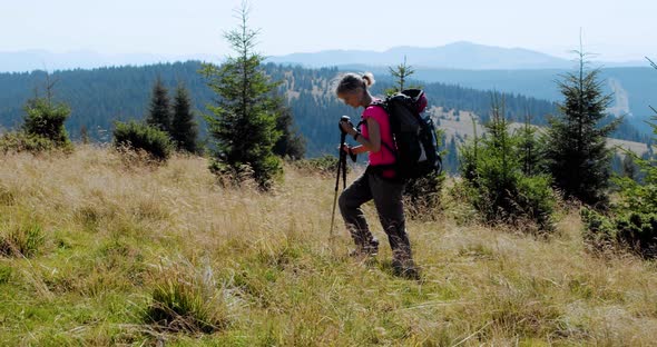 Woman Hiking in Mountains with Backpack, Enjoying Her Adventure. Slow Motion V3