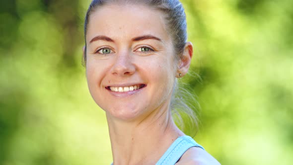 Young woman with fair hair bun turns head