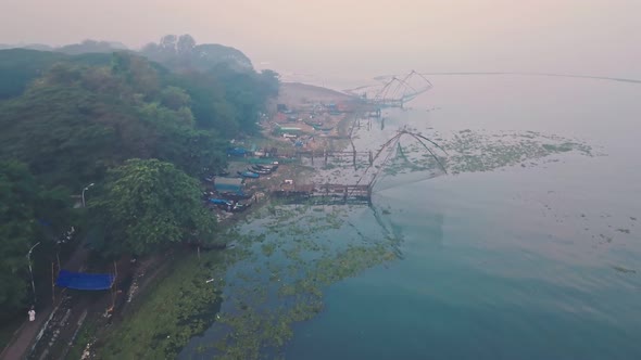 Traditional Chinese fishing nets in Fort Kochi at sunrise, India. Aerial drone view