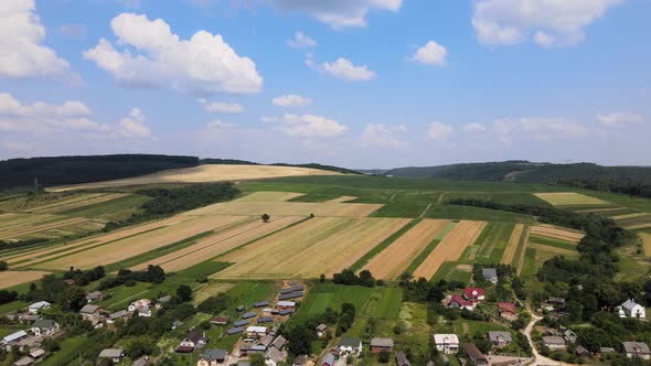 Aerial Landscape View of Village Houses and Distant Green Cultivated Agricultural Fields with