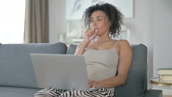 Sick African Woman with Laptop Coughing at Home