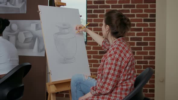 Young Woman Using Pencil to Draw Masterpiece on Canvas