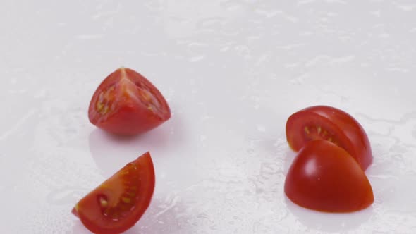 Red Tomato Divided Into Slice on a White Background. Slow Motion