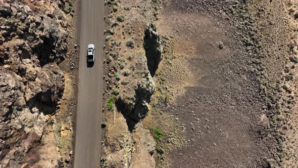 Top down shot of a truck driving on a rocky highway.