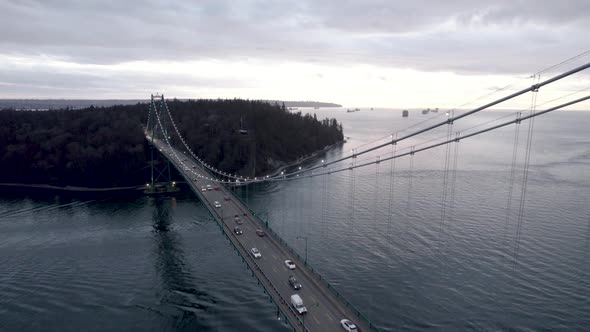 Vehicles driving on Lions Gate Bridge crossing Burrard Inlet fjord, Vancouver in Canada. Aerial forw