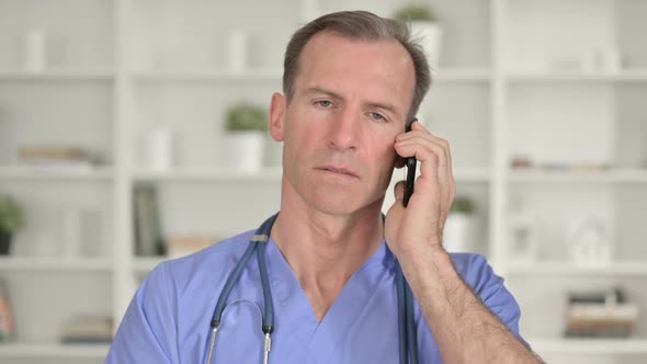 Portrait of Cheerful Middle Aged Doctor Talking on Smartphone