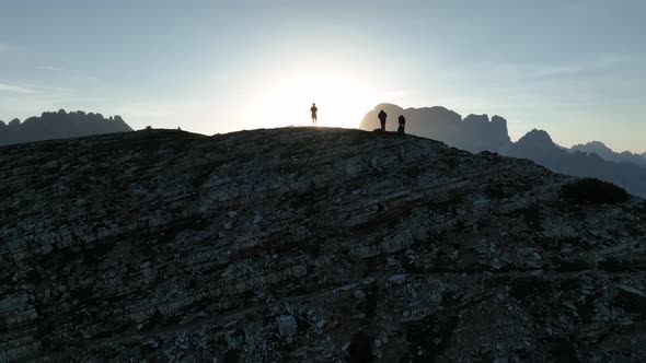 Female and male hikers at the top of the mountain at sunrise.
