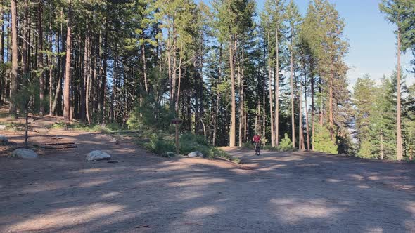 Caucasian man riding a mountain bike up a slope on a curve in Ashland, Oregon