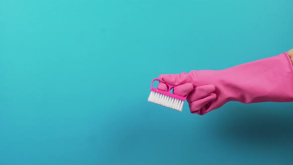 On the Right a Pinkgloved Hand with a Hardpile Plastic Cleaning Brush