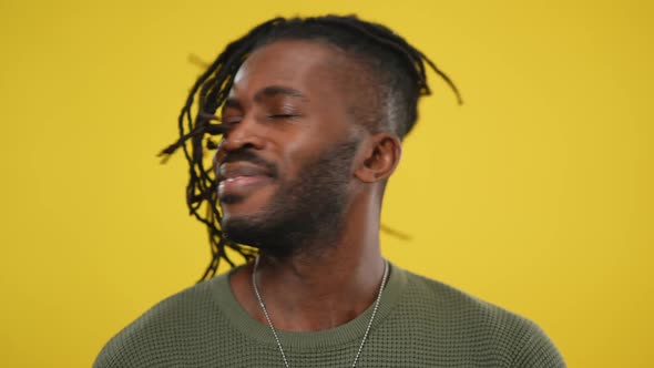 Headshot of Cheerful African American Handsome Man Shaking Dreadlocks on Head Smiling Looking at