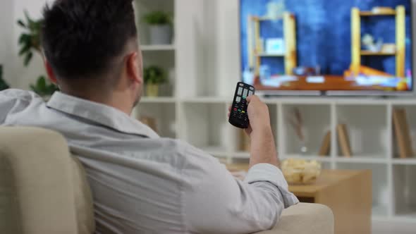 Man Watching Vlogs on TV in Living Room