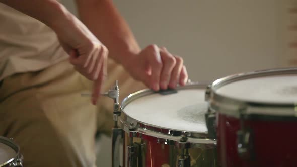 Drummer preparing snare drum by tuning it before practice begins.