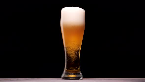 Light Beer Pouring in Glass. With Bubbles and Foam