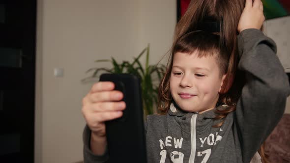 Boy Holds a Smartphone Girl Throws Her Hair Over His Head