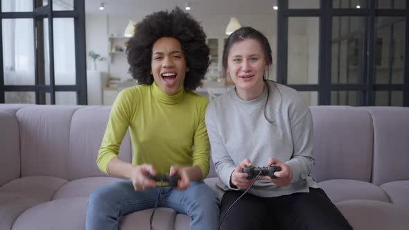 Portrait of Young Joyful Female Gamers Giving Highfive Playing Multiplayer Video Game