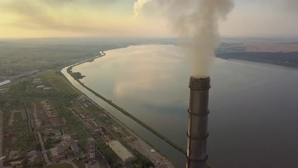 Aerial view of high chimney pipes with grey smoke from coal power plant. Production of electricity 