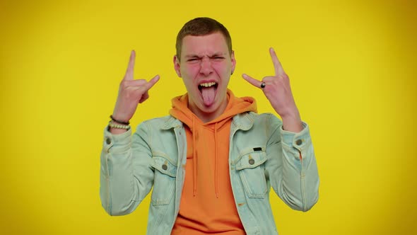 Overjoyed Teen Man Showing Rock n Roll Gesture By Hands Cool Sign Shouting Yeah with Crazy Face