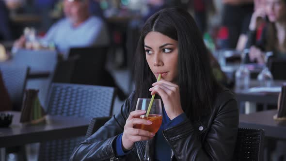 pretty young Asian woman  at the restaurant,drinking cocktail