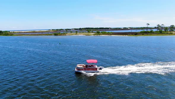 Drone shot of a pontoon boat cruising through the Okaloosa sound next to Destin in northwest Florida