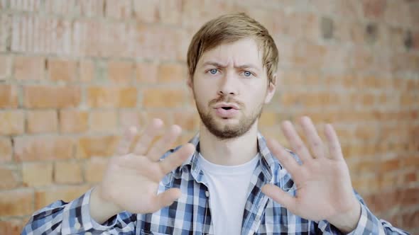 Portrait of Young Man Trying to Avoid Offer, Dislike, Rejecting, Disagree