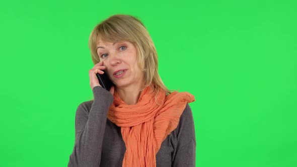 Portrait of Middle Aged Blonde Woman Is Talking for Mobile Phone. Green Screen