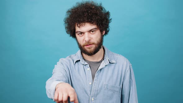 Young Man with Kinky Hair Shows Threat Beating Fist on Palm