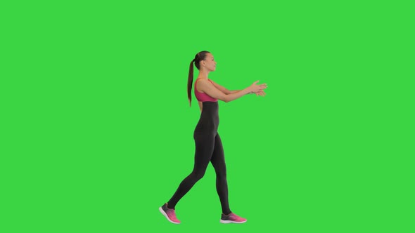 Female Athlete Warming Up While Walking on a Green Screen Chroma Key