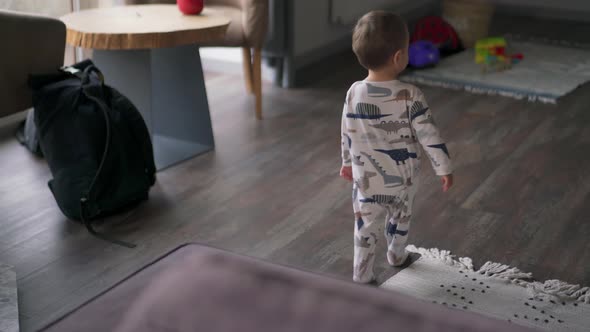 Back view of little child walking at home