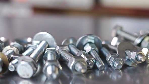 Slider Shot Video of Chrome Bolts and Nuts in a Chaotic Order Industrial Background