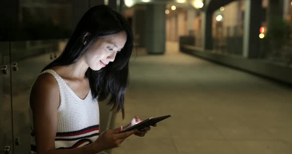 Woman working on cellphone at night 