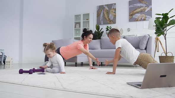 Happy Mother Doing Push-Ups Together with Her Handsome Teen Son