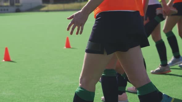 Female hockey players exercising on the field