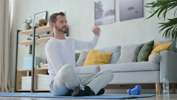 Man Doing Stretches on Yoga Mat at Home