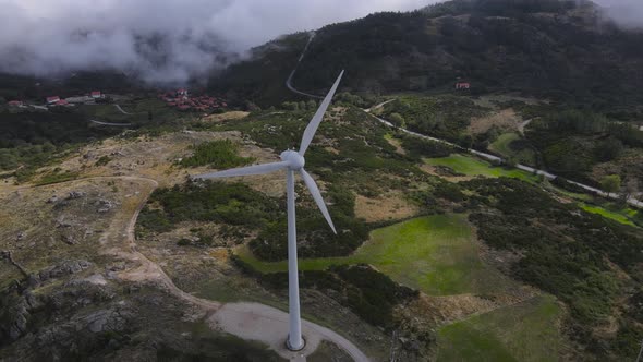 Aerial circling around wind turbines with blades spinning, Caramulo. Portugal