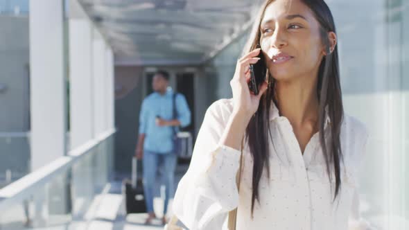 Video of happy biracial woman walking and using smartphone