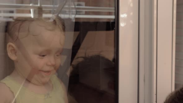 Children smiling to each other through the window