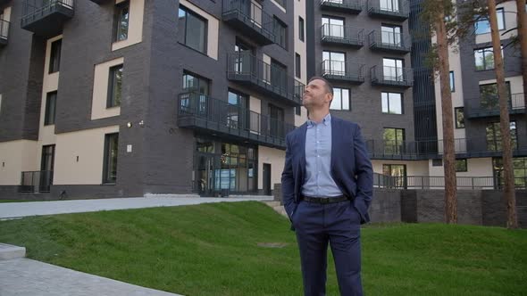 Businessman Standing Near with Home and Enjoy View