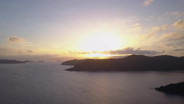 Aerial view of majestic bright sunrise behind seascape with islands in Asia - camera pedestal up