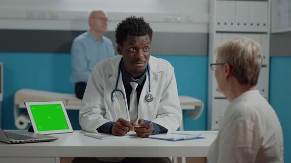 African American Medic Discussing with Senior Woman alt