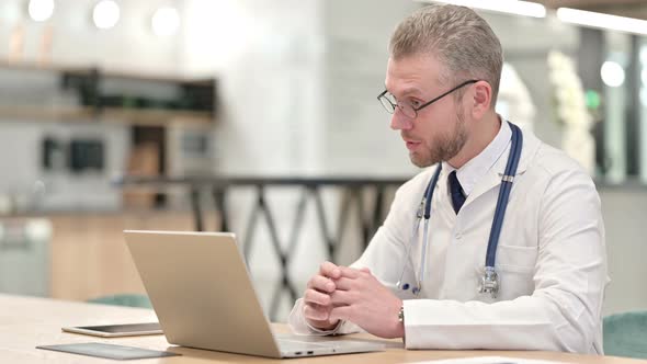 Male Doctor Doing Video Call on Laptop in Office 