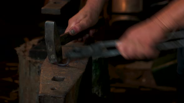 Blacksmith in Forge Beats Hot Metal on Anvil with Hammer