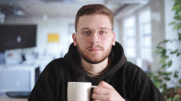 Office Worker with Coffee Having Videochat