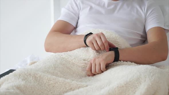 Young Man with Smartwatch Lying in Bed.